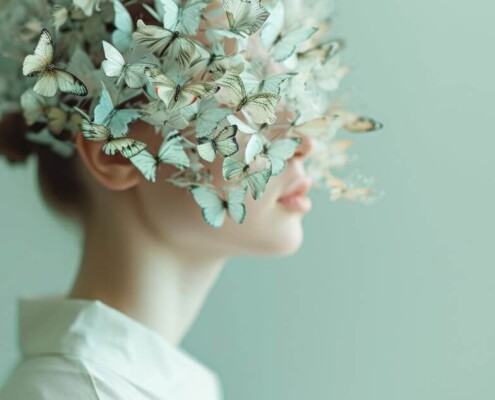 Woman surrounded by butterflies representing the uniqueness of neurodivergent individuals and creativity of autistic clients.