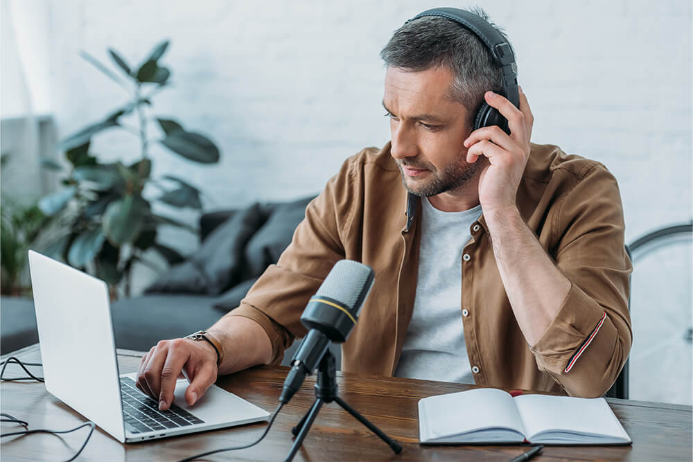 Male pod caster at work in his home office