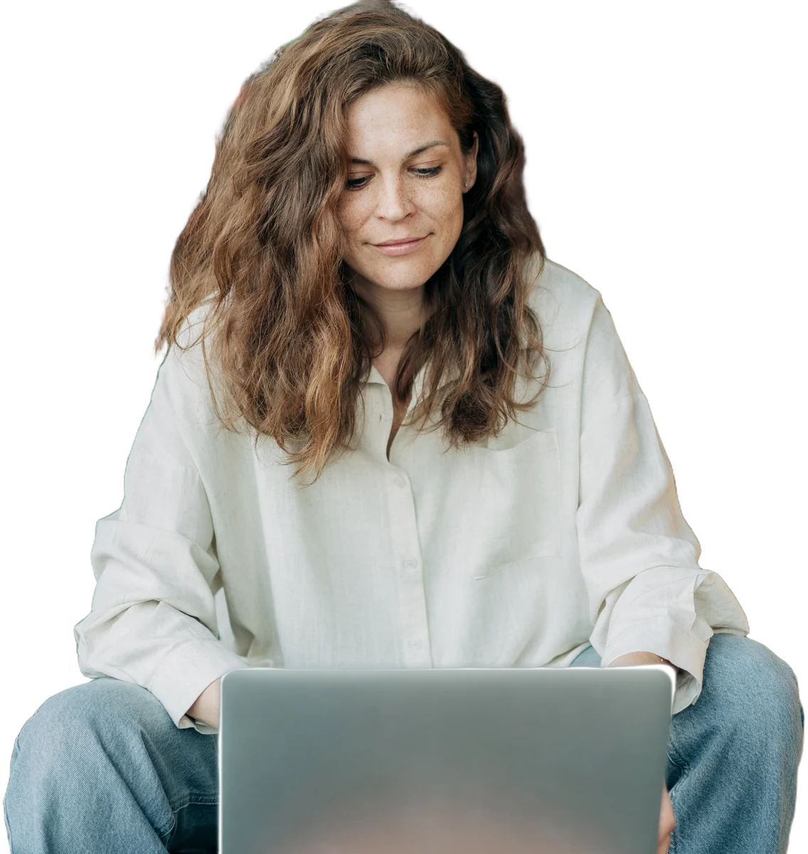 A therapist with long curly hair working on her laptop
